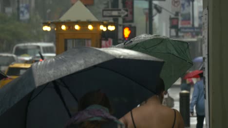 gente caminando bajo la lluvia bajo los paraguas