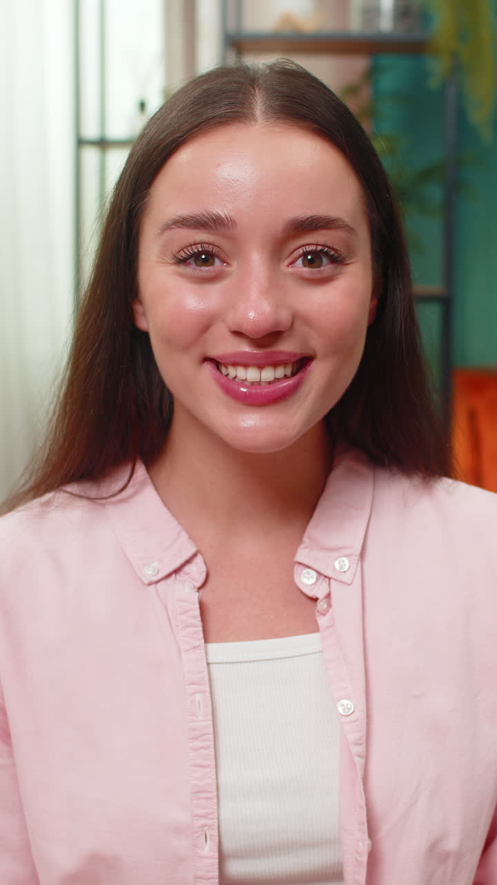 Young woman exclaiming wow with wide eyes huge joyful surprise reaction holding smartphone on sofa