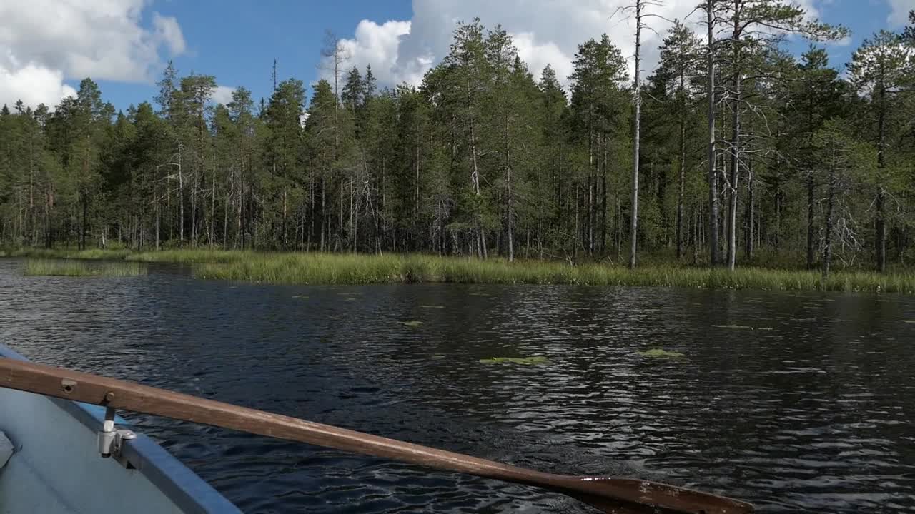 Boat rowing in lake calm water, Finland