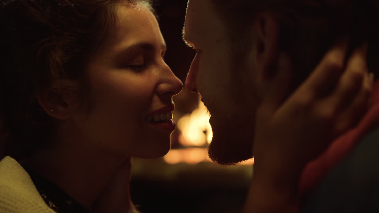 Sensual couple kissing relax at fireplace. Lovers enjoy date in vacation house.