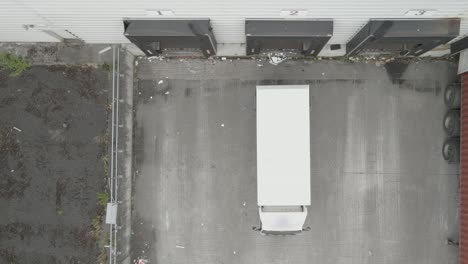 Delivery-Truck-Reversing-Into-A-Loading-Dock-Of-A-Warehouse-In-Dublin,-Ireland