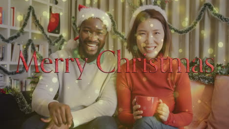 holding mugs, smiling couple with santa hats celebrating christmas against festive background