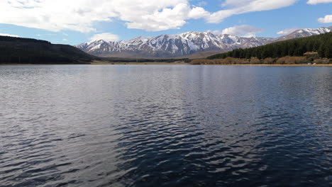 flying low over la zeta lake towards snow-capped andes mountains near esquel, argentina