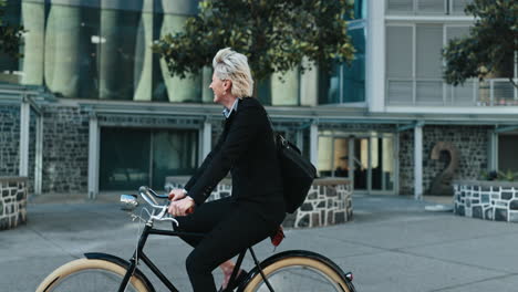 businesswoman, happy and riding a bike to work