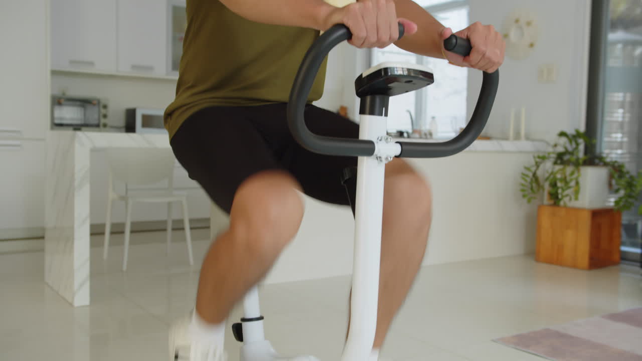 Athlete Watching Video on AR Glasses while Exercising on Fitness Bike