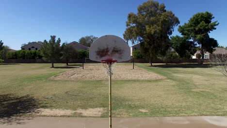 drone footage of scottsdale city park, basketball court level with hoop then tilt down