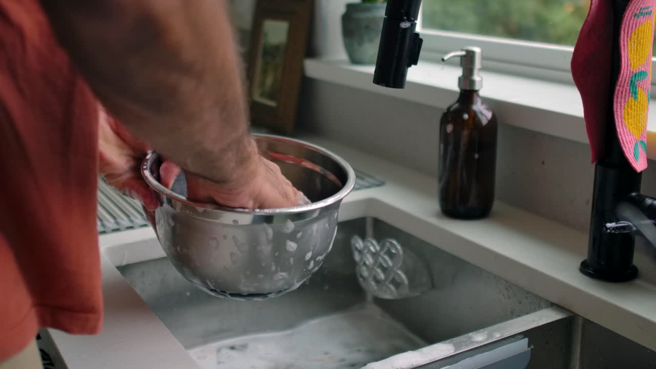 Man Washing Dishes with Sponge at Kitchen Sink - Close Up Hands
