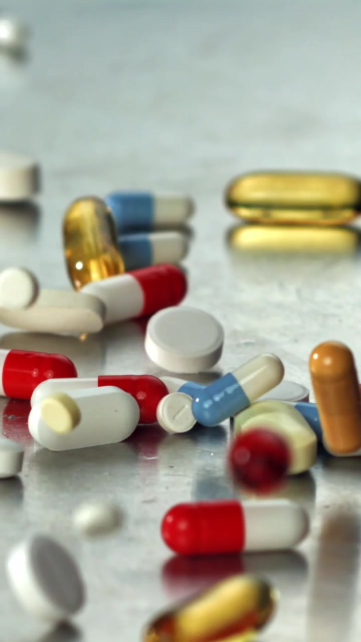 Colorful Pills and Capsules Falling in Slow Motion