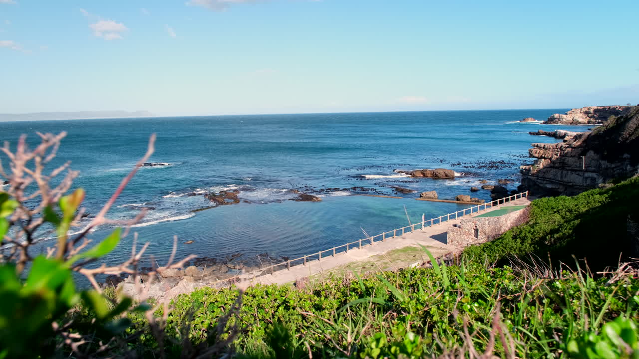 Scenic elevated slider view over Atlantic ocean and marine tide pool of Hermanus
