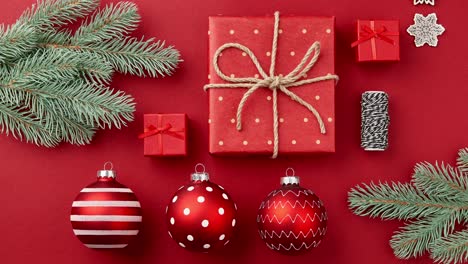 animación de stop motion con navidad año nuevo cajas de regalos, adornos, ramas de árboles de navidad se mueve en la mesa roja