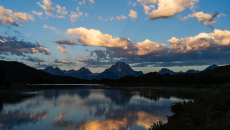 grand teton mountains and clouds reflected in water at sunset