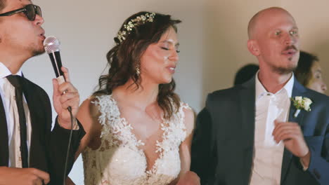 joyful moments where the bride and groom sing alongside a vocalist during their wedding celebration.