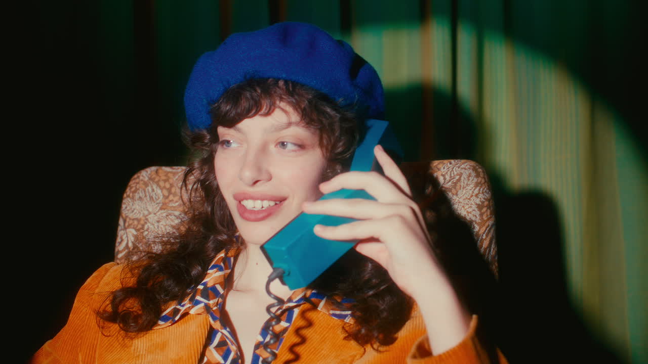 Young Woman Wearing Blue Beret Smiling and Talking on Retro Telephone