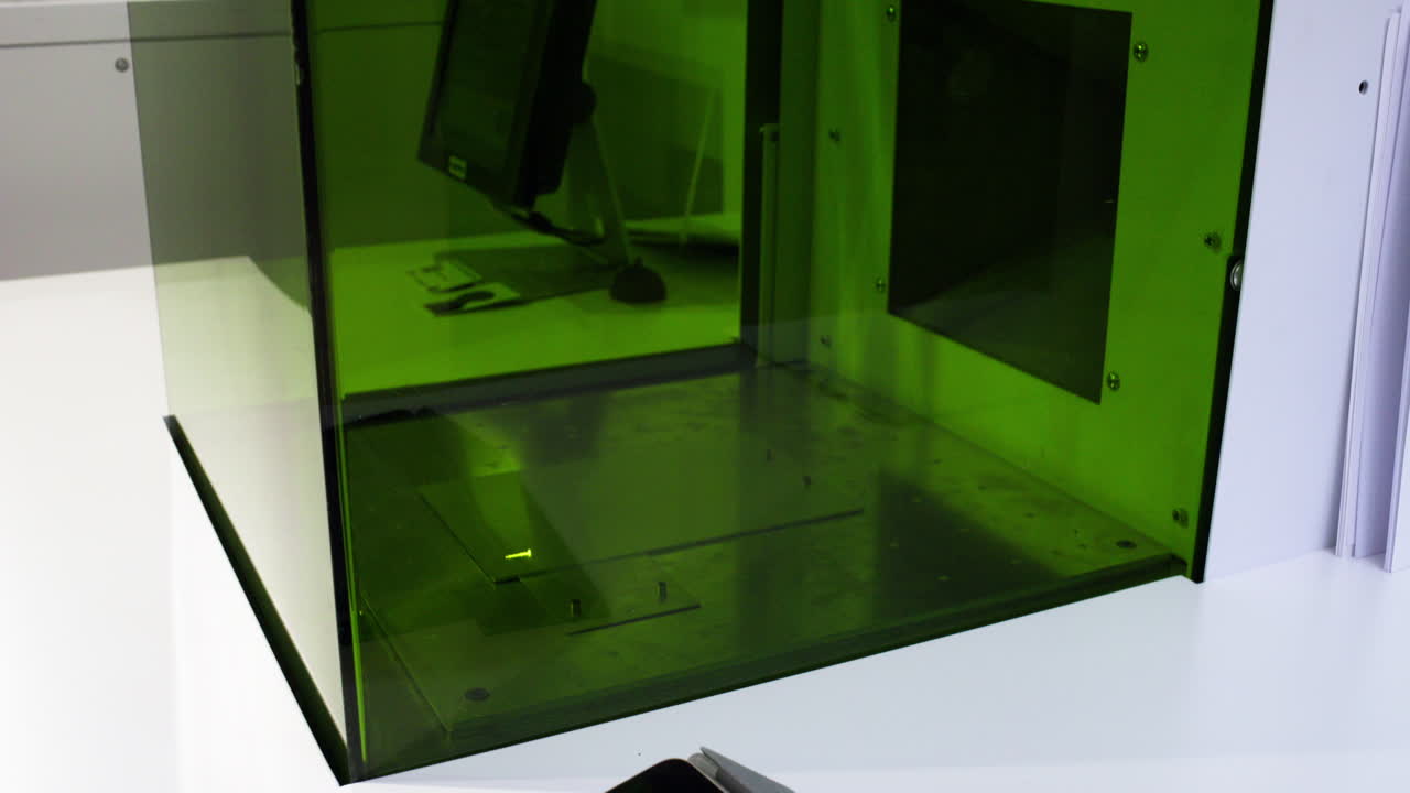 лазерная гравировка рисунка на металлической пластине за зеленым защитным стеклом