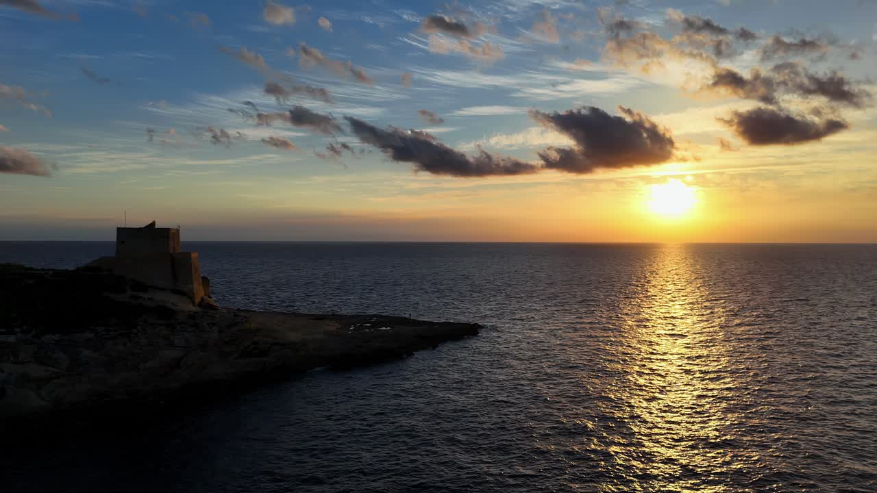 Vista aerea grandangolare della baia di Daħlet Qorrot e della storica torre di avvistamento Sopu al tramonto a Gozo
