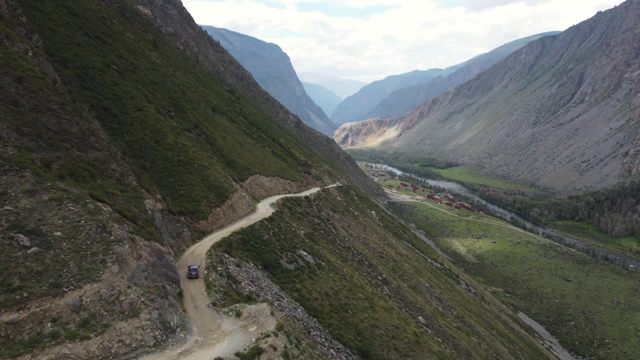 Aerial view of black SUV driving along steep dangerous road