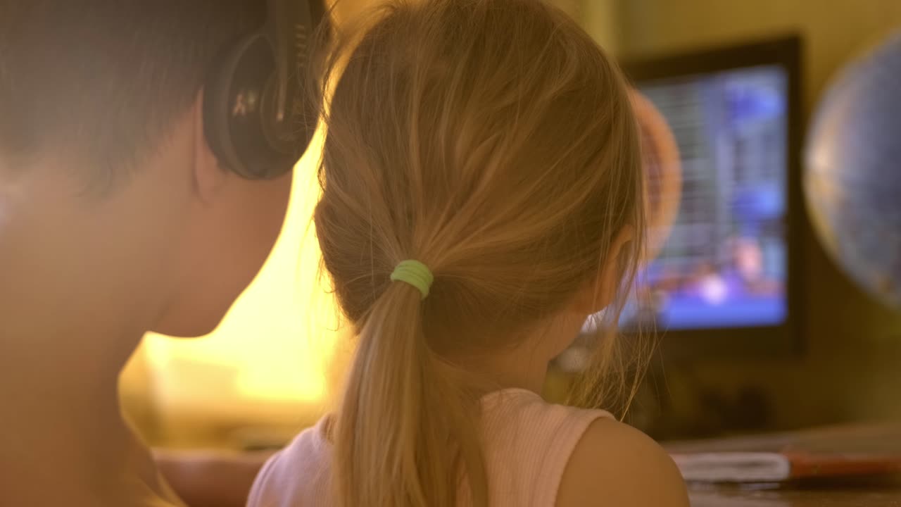Siblings watching something on a computer