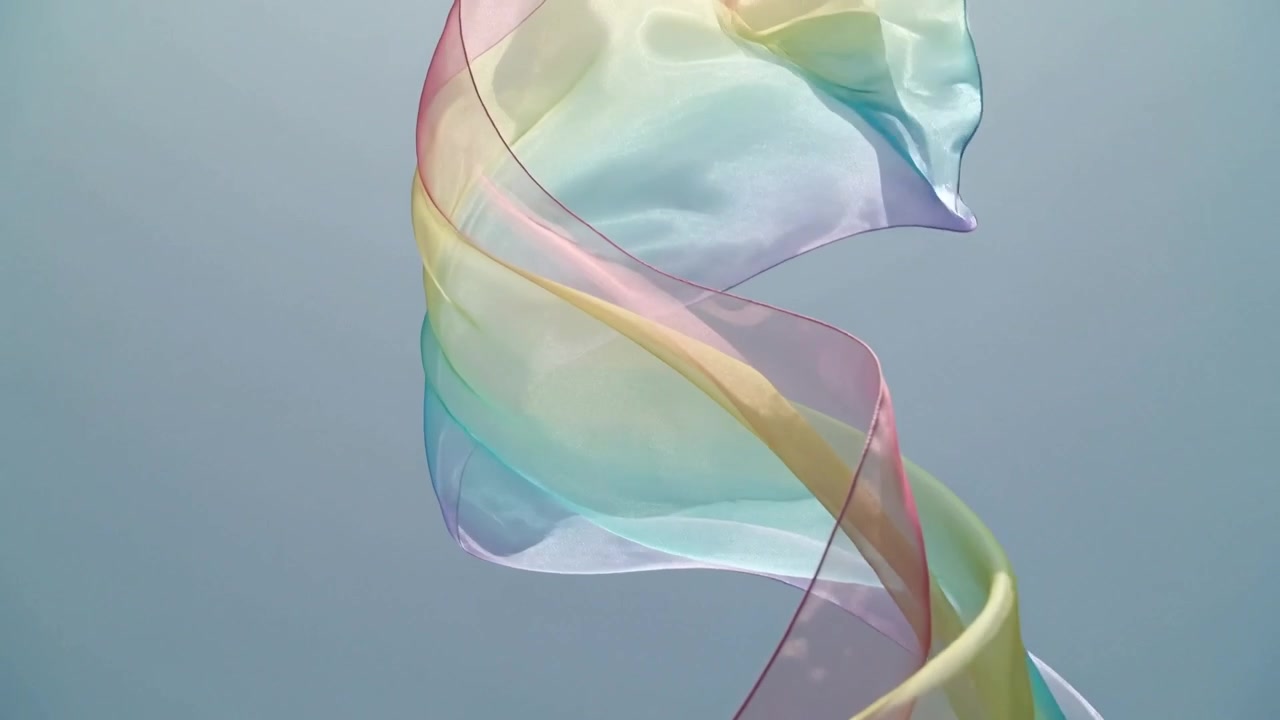 Floating pastel silk scarf driven by light breeze, twisting and unfurling against pale-blue sky