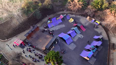 aerial view of a group of people skating in a skate park in parque araucano, santiago, chile