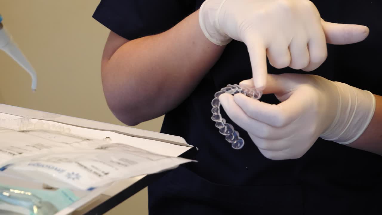 Dentist preparing Invisalign aligner during an orthodontic appointment