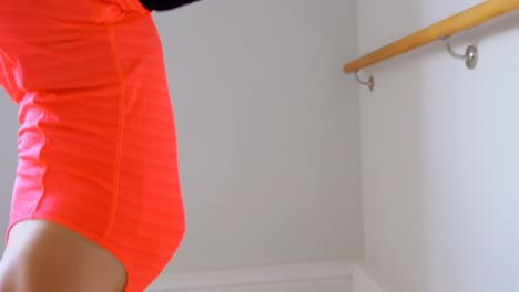 mujer haciendo postura de inversión en barre en el estudio de fitness 4k