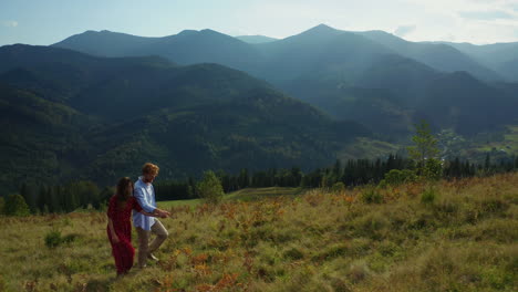 joyful lovers in mountains drone view against amazing woods pikes background