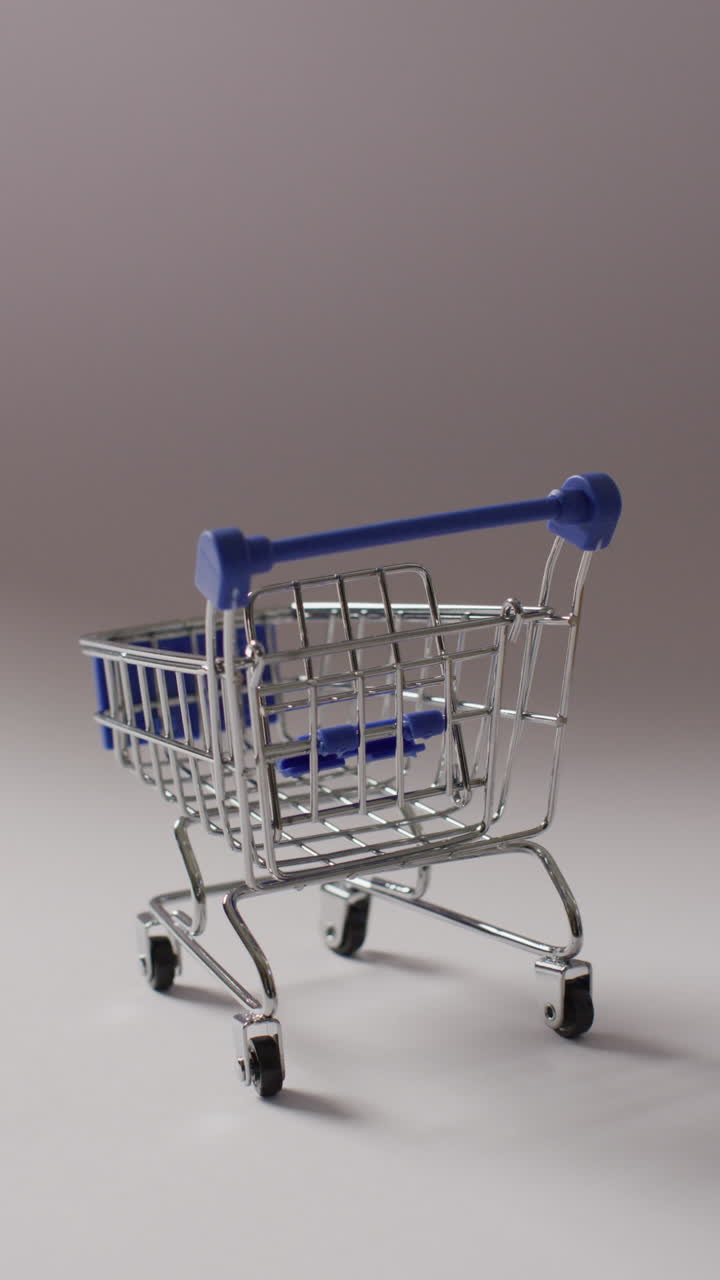 video vertical de un carrito de compras vacío sobre un fondo gris