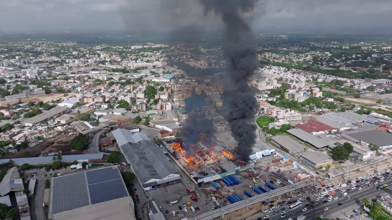 Densa columna de humo negro de un almacén en llamas, Santo Domingo
