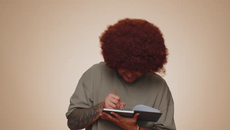 thoughtful journalist man making notes, writing down thoughts with pen into notepad notebook diary