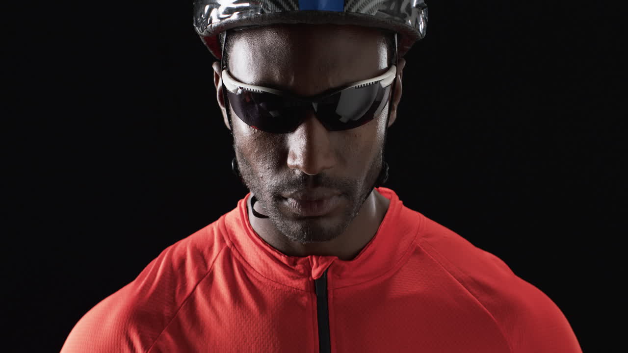 el ciclista afroamericano posa con confianza sobre un fondo negro