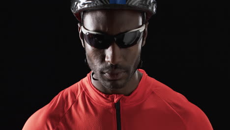 african american cyclist poses confidently on a black background