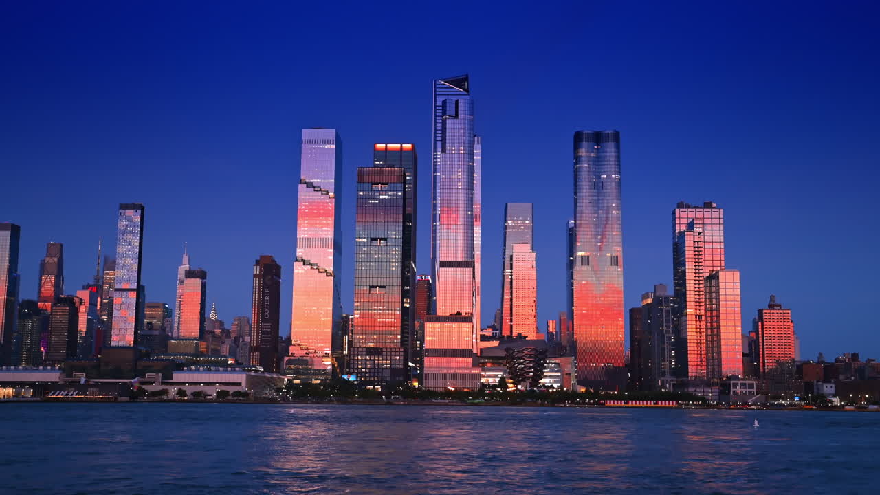 New York, USA, 8 July 2025: Glass skyscraper reflect the light of setting sun. Low angle view at the stunning high-rises on the waterfront of New York, USA. View from the river
