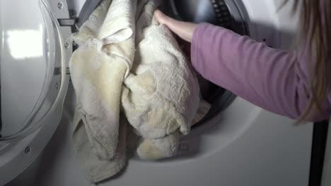 Woman-loading-washing-into-a-washing-machine-medium-shot