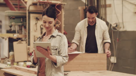 a young female carpenter using a digital tablet