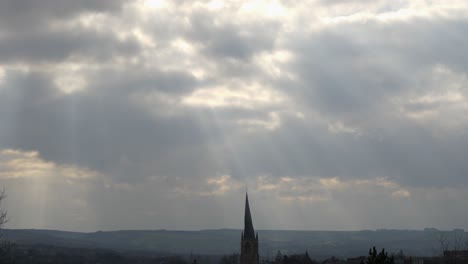 a timelapse of dramatic clouds and sunlight passing over a church spire, the crooked spire in chesterfield