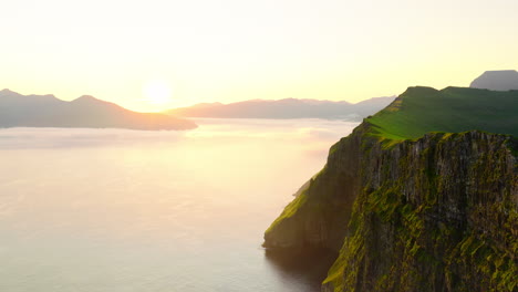Dramatic Coastal Cliffs at Golden Hour with Misty Ocean