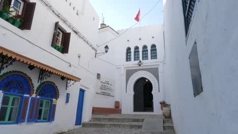 bandera de marruecos ondea sobre antiguas fortificaciones kasbah en el corazón de la bulliciosa medina de tánger