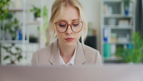rostro de una mujer concentrada trabajando en una computadora portátil