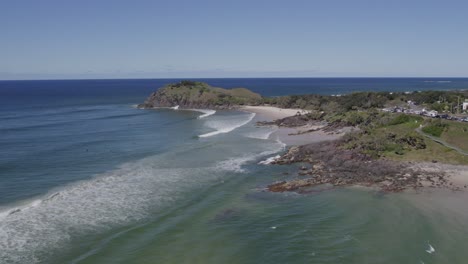 olas espumosas salpicando en la orilla arenosa en la playa de cabarita en nsw, australia - toma aérea de drones