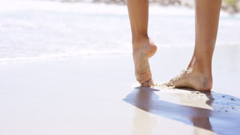 close up of woman feet walking on tropical beach island vacation