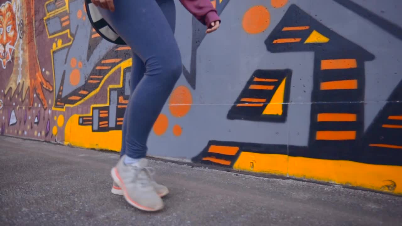 mujer caminando a lo largo de una pared de graffiti colorida y vibrante
