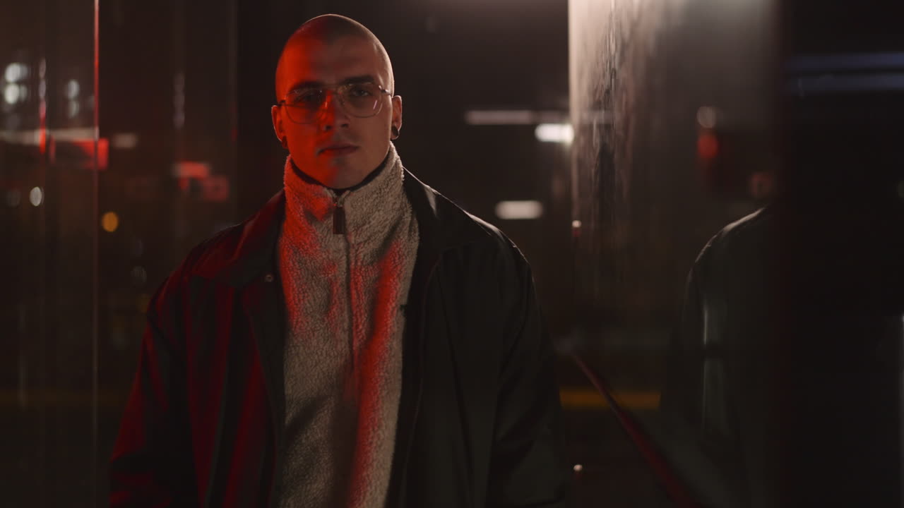 Portrait of a Bald Man with Glasses in Red Lit Urban Setting at Night