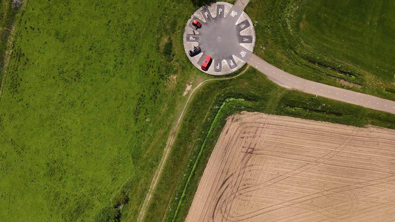 Luftfoto av sirkulær parkeringsplass ved siden av jordbruksmarker