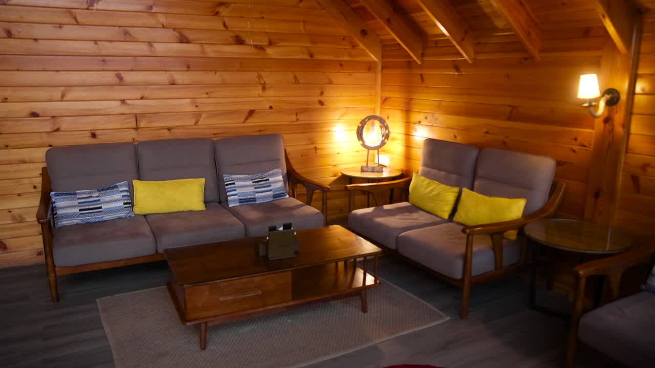 Comfortable cozy couch sofas in a warm rustic wooden cabin, no people