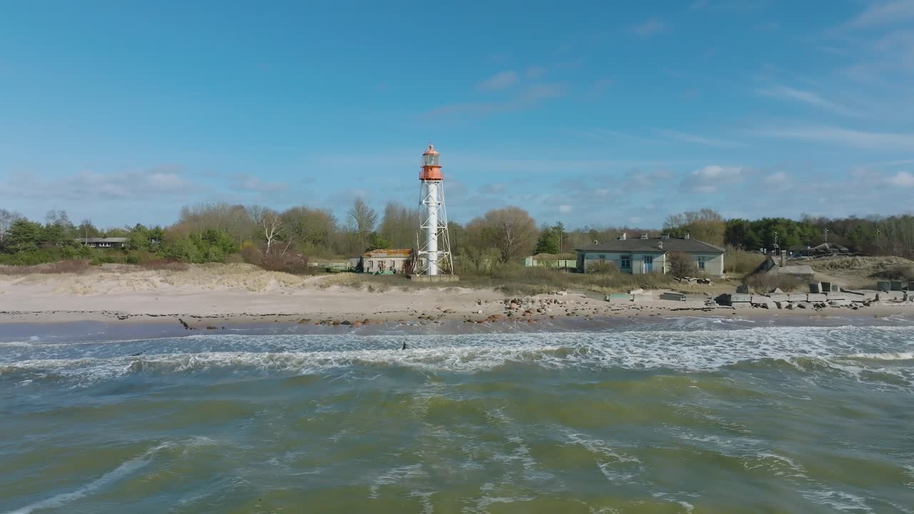 ⁇ 색 파페 등대, 발트해 연안, 라트비아,  ⁇  모래 해변, 큰 파도가 부 ⁇ 히는, 구름이 있는  ⁇ 빛 날, 넓은 상승 드론  ⁇ 도 촬영