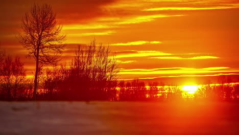 golden glowing sunset on a snowy, winter landscape - time lapse