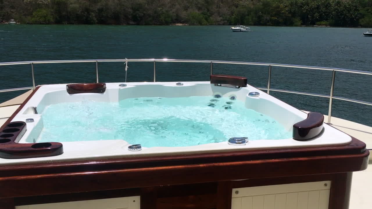 jacuzzi en la cubierta del barco con vistas a la costa tropical en un día soleado