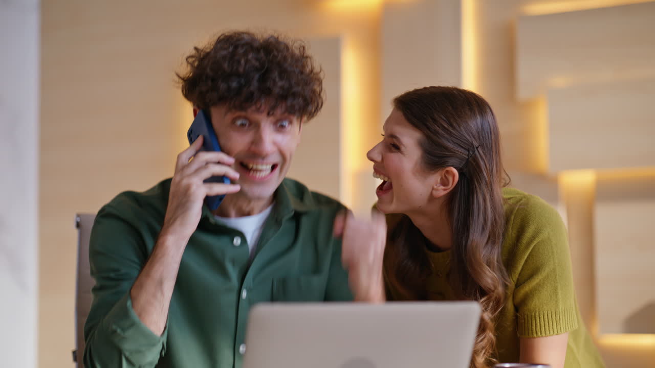 Excited Couple Celebrating Good News on a Phone Call