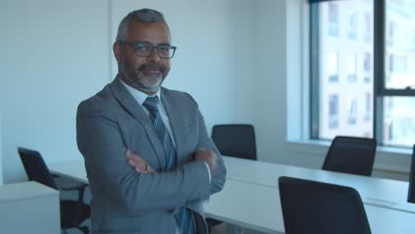 positive confident mature businessman standing in office