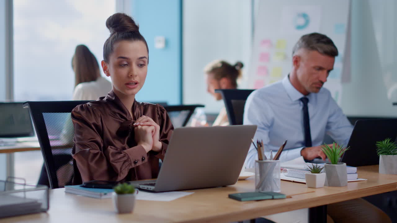 mujer de negocios sonriente haciendo gestos con las manos durante una llamada de video